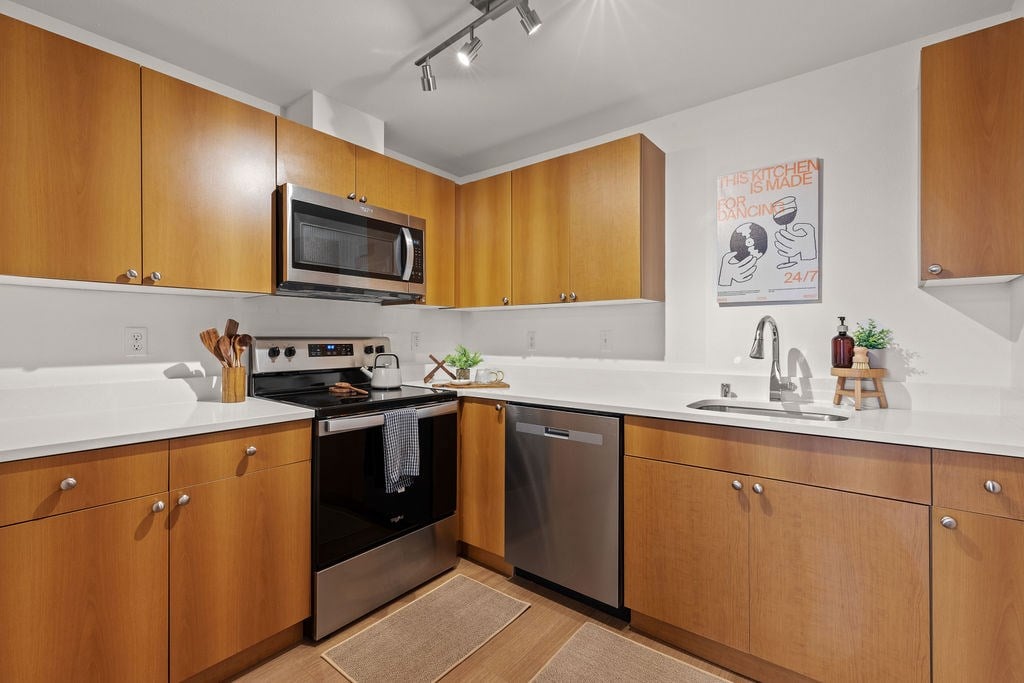 A kitchen with wooden cabinets and a white counter top.