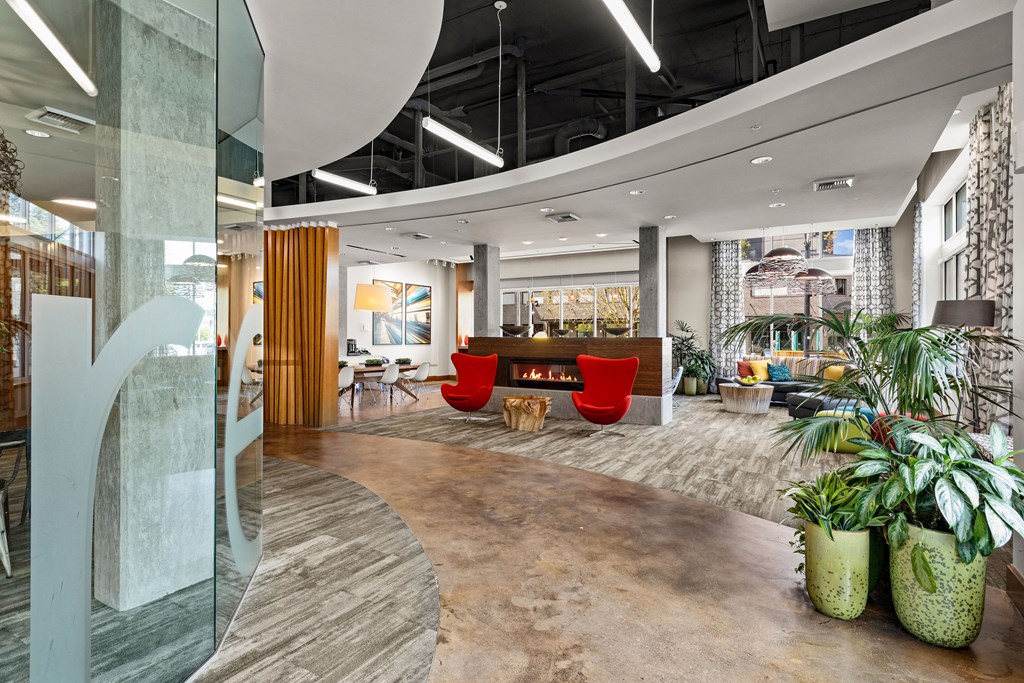 the lobby of an office with a fireplace and plants