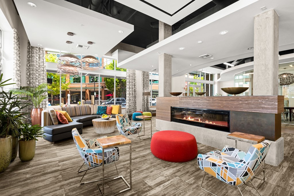 the lobby of a hotel with a fireplace and seating