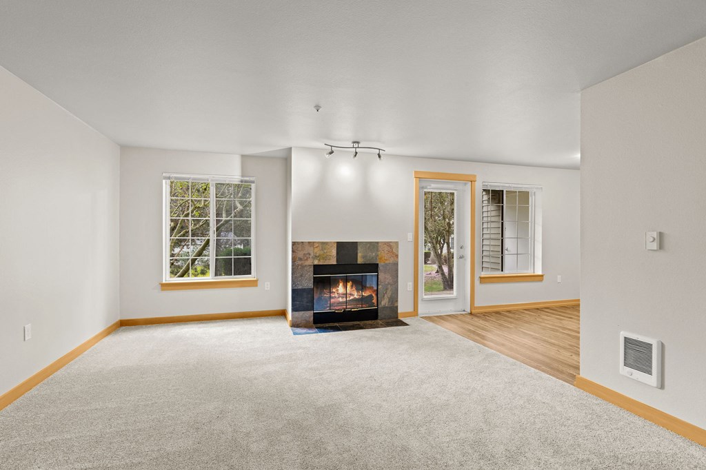 A living room with a fireplace and a carpet.