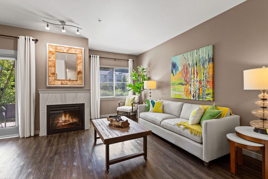 A living room with a fireplace and a painting on the wall.