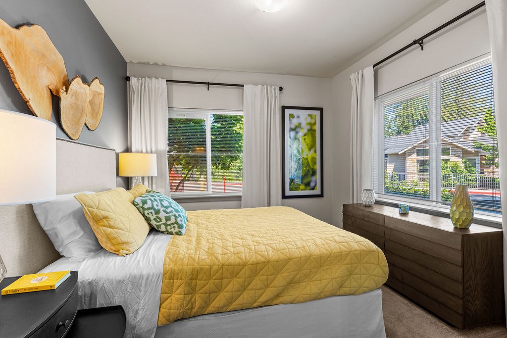 A bedroom with a bed, nightstand, and window.