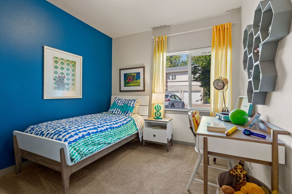 A bedroom with blue walls and a bed with a blue and white comforter.