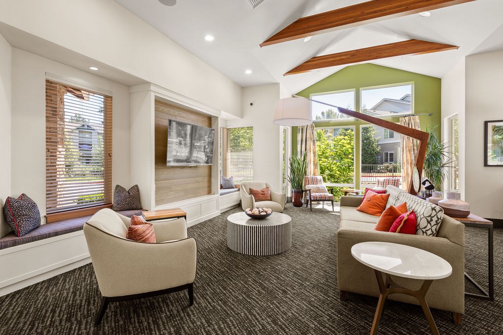 A living room with a large window and a view of a house.