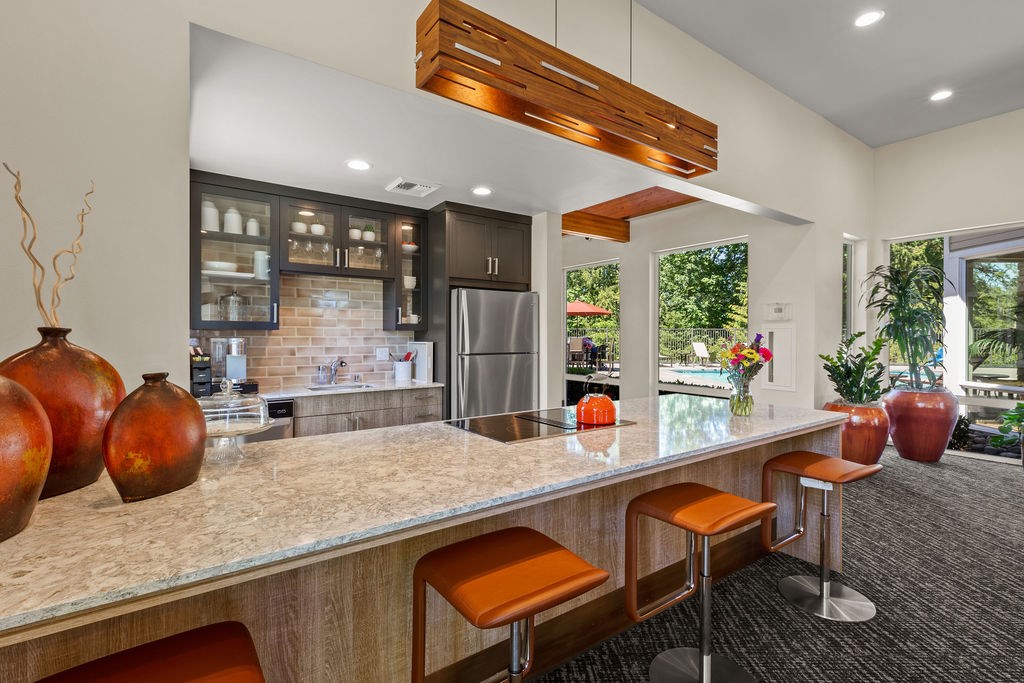 A kitchen with a bar area and a refrigerator.