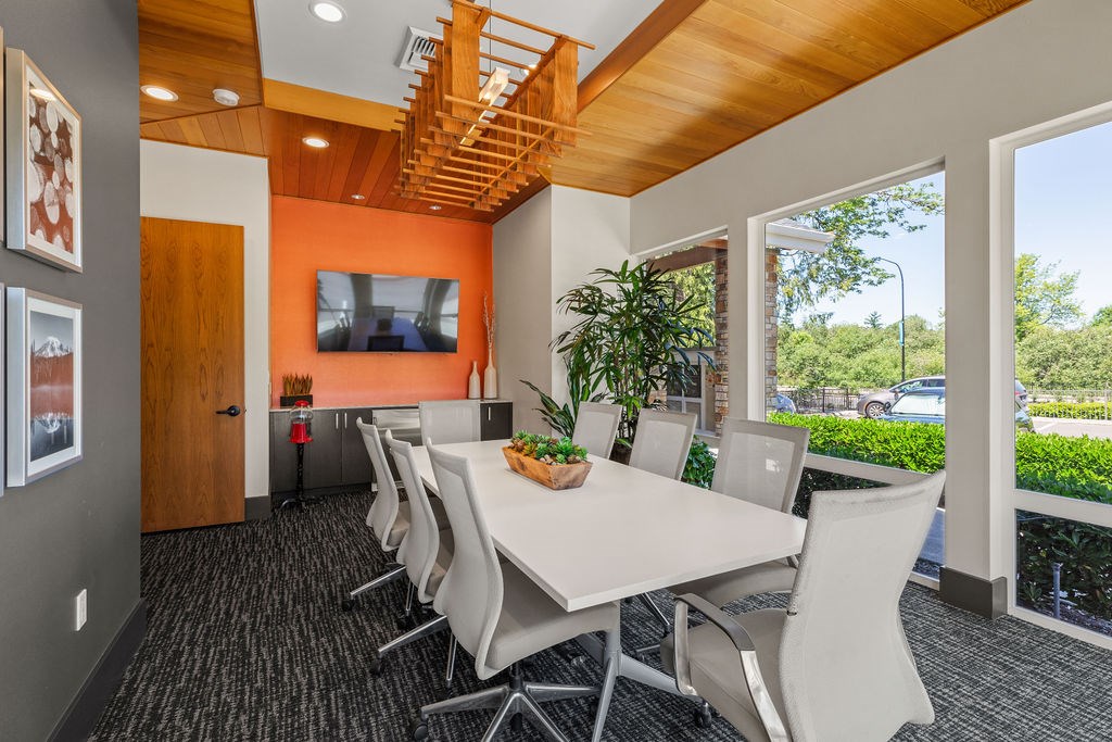 A conference room with a long table and chairs.