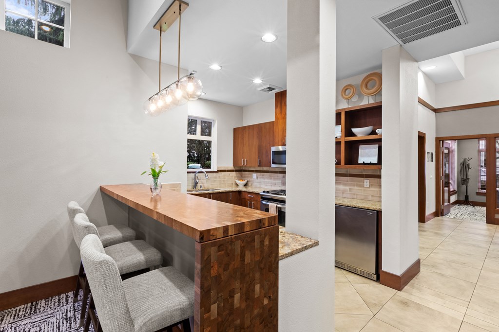 a kitchen with a bar and chairs in a house