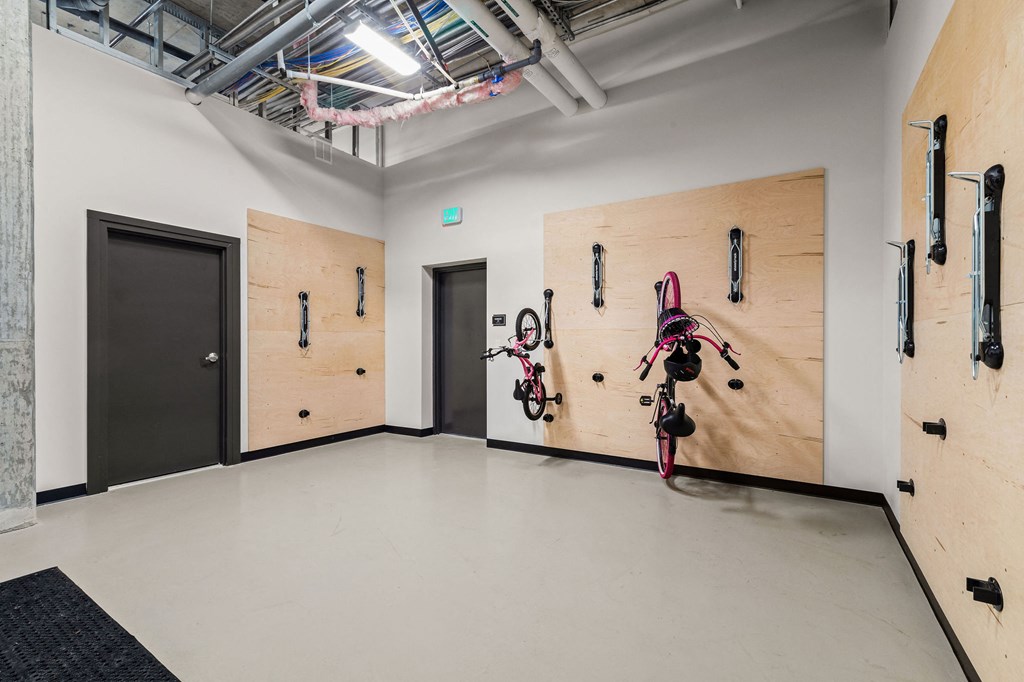a white room with two wooden doors and bikes on the wall