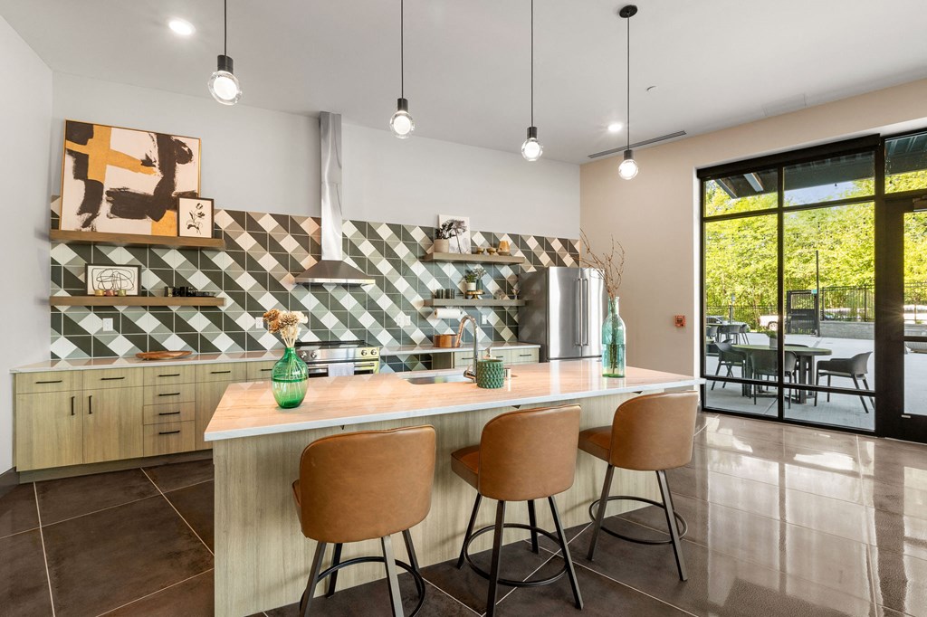 a kitchen with a counter and three chairs