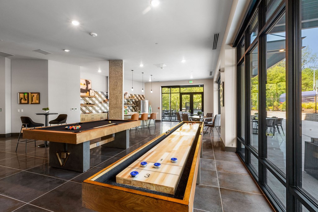 a game room with a shuffleboard table and a pool table