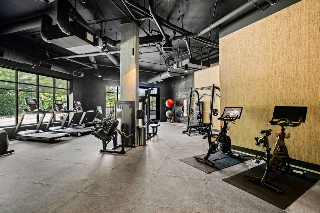 a workout room with treadmills and other exercise equipment