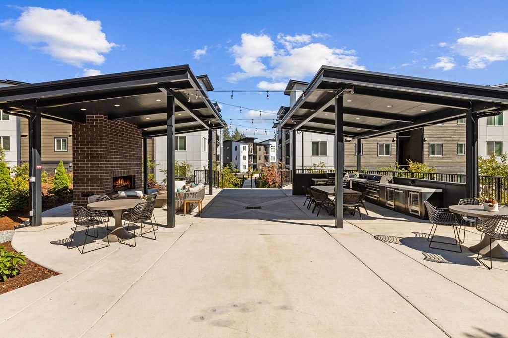 a patio with tables and chairs and a fire pit