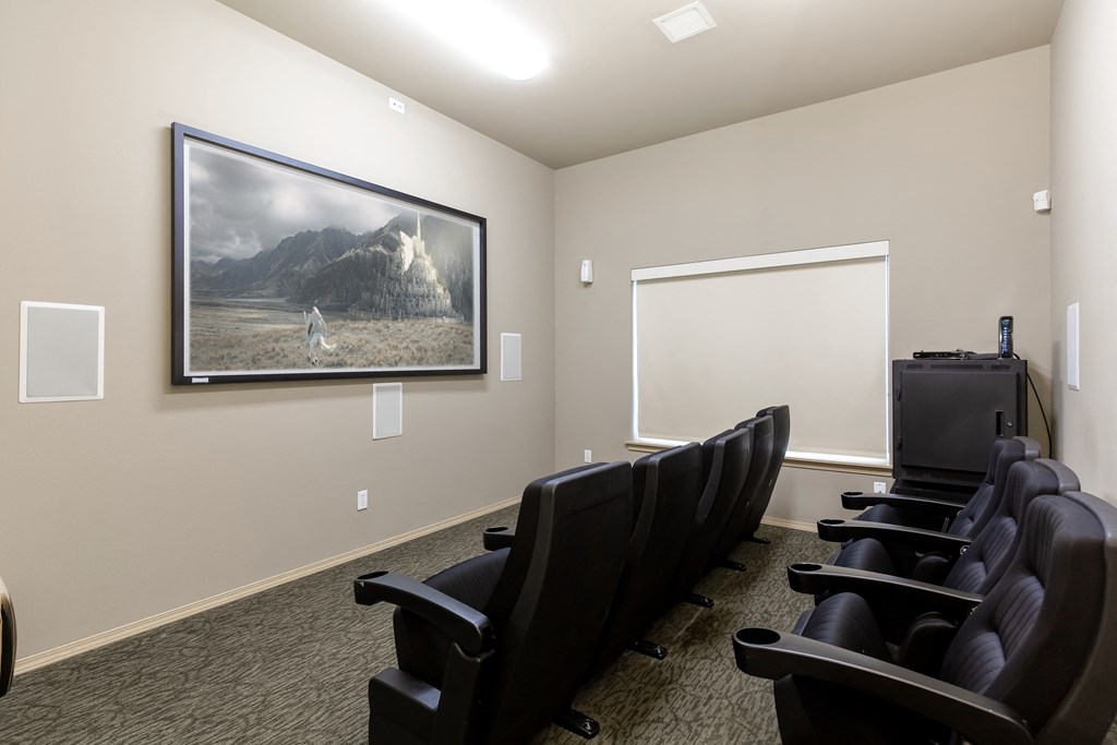 a conference room with a projector screen and chairs