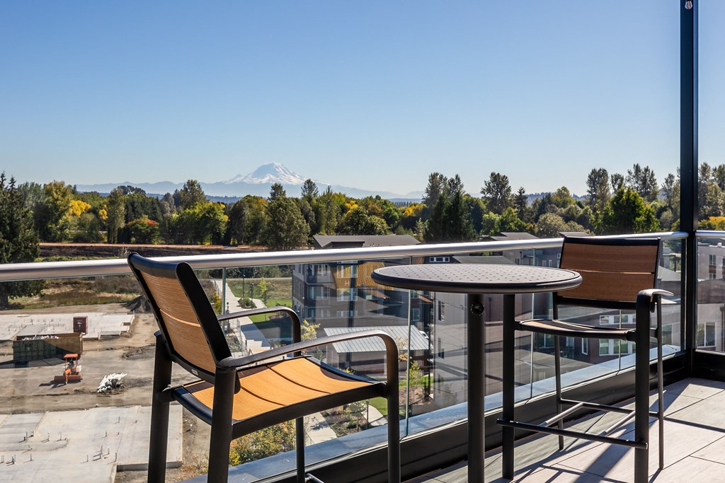 a balcony with a table and chairs and a view of a mountain