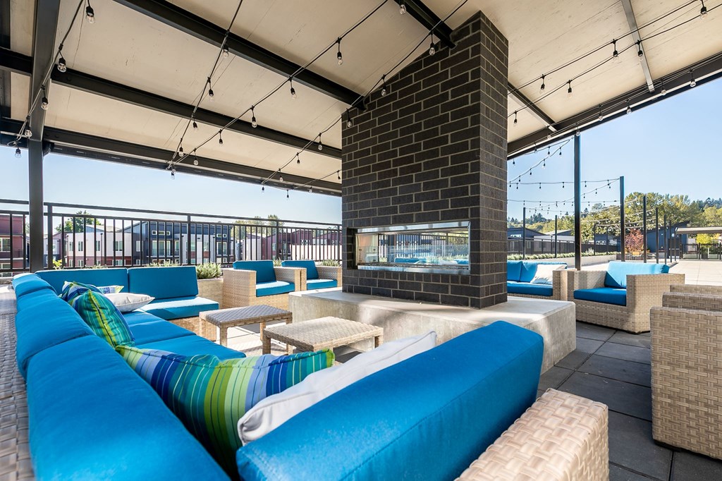 a lounge area with blue couches and a fireplace