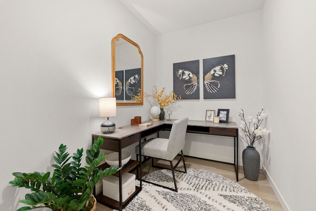 an office with a desk and a mirror and a plant