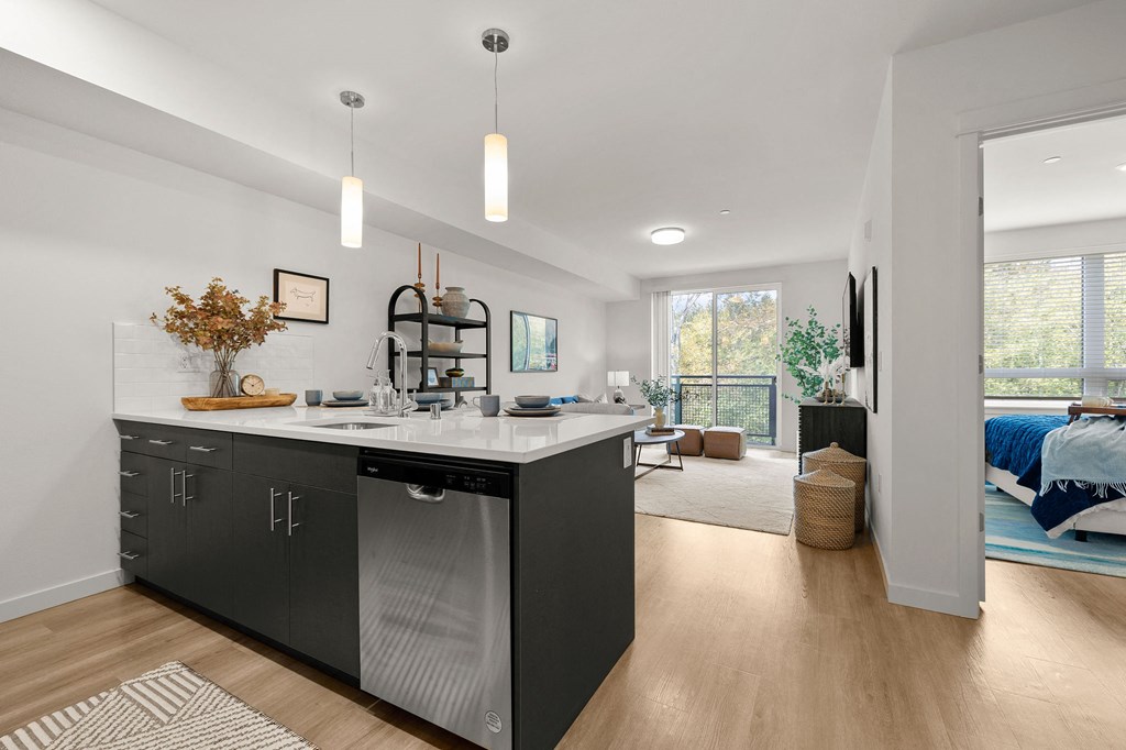 a kitchen with an island and a bedroom in the background