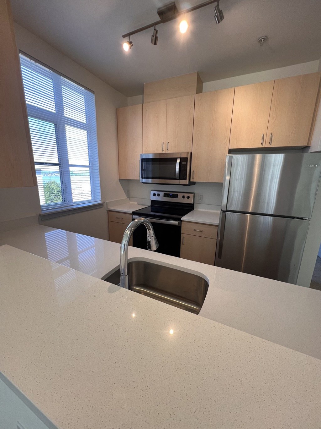 a kitchen with stainless steel appliances and a white counter top