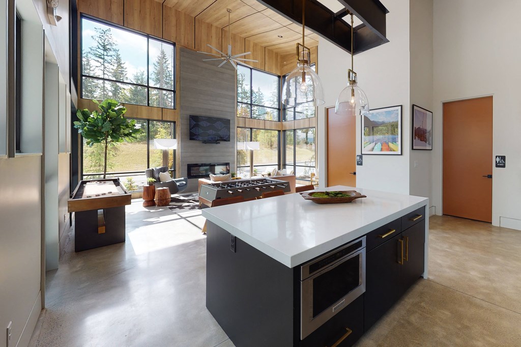a large kitchen with a large island and a living room with a fireplace