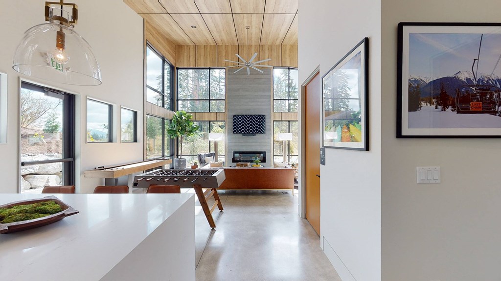 a kitchen and dining room with large windows and a white counter top