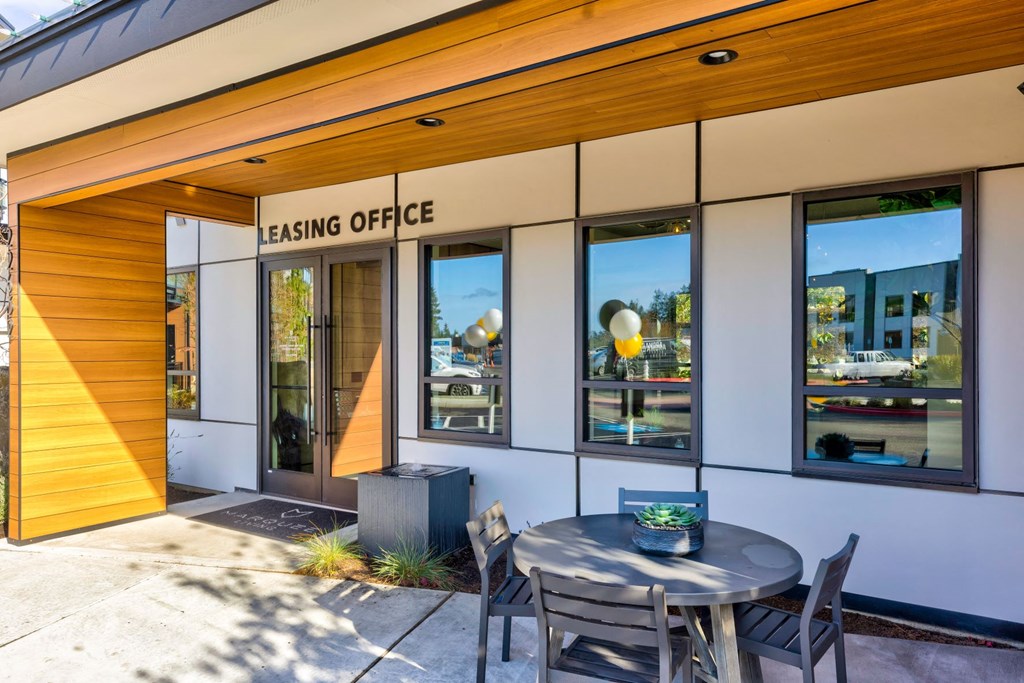 a patio with a table and chairs outside of a leasing office