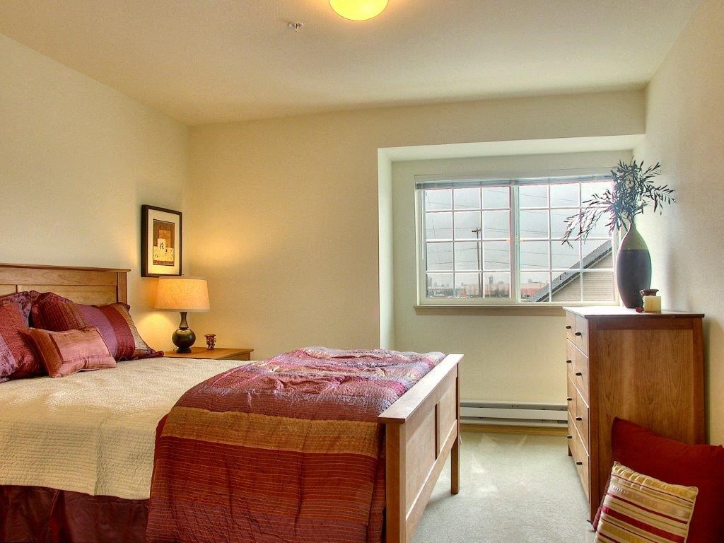 a bedroom with a bed and a dresser and a window