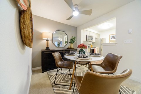 A dining room with a round table and chairs.
