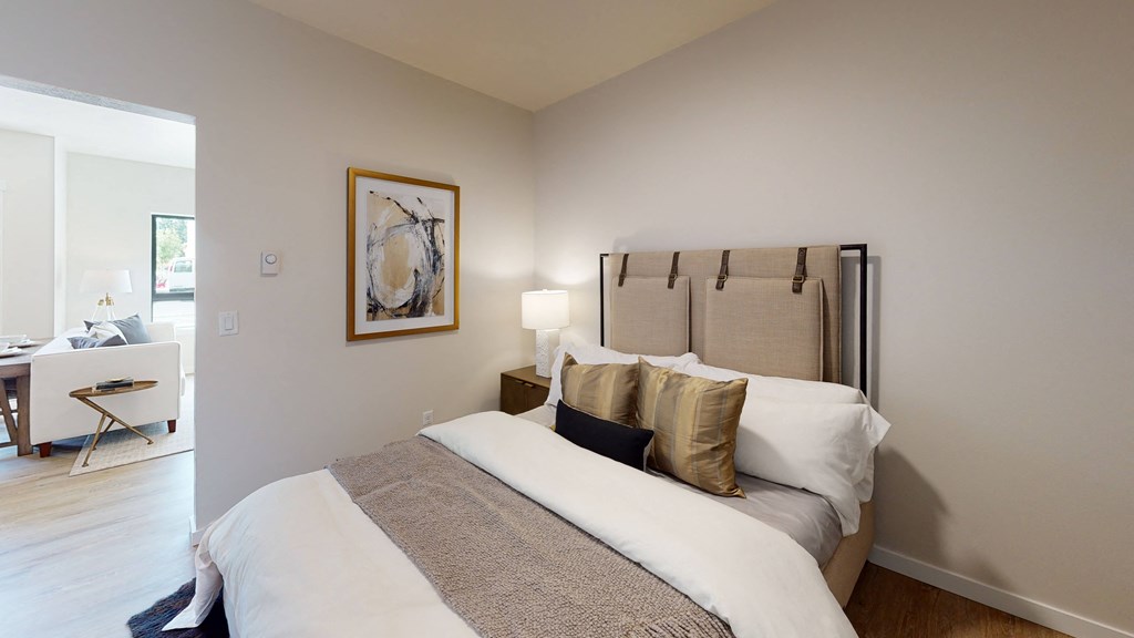 a bedroom with a large bed and a desk with a chair