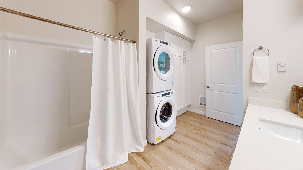 a washer and dryer in a bathroom with a shower curtain