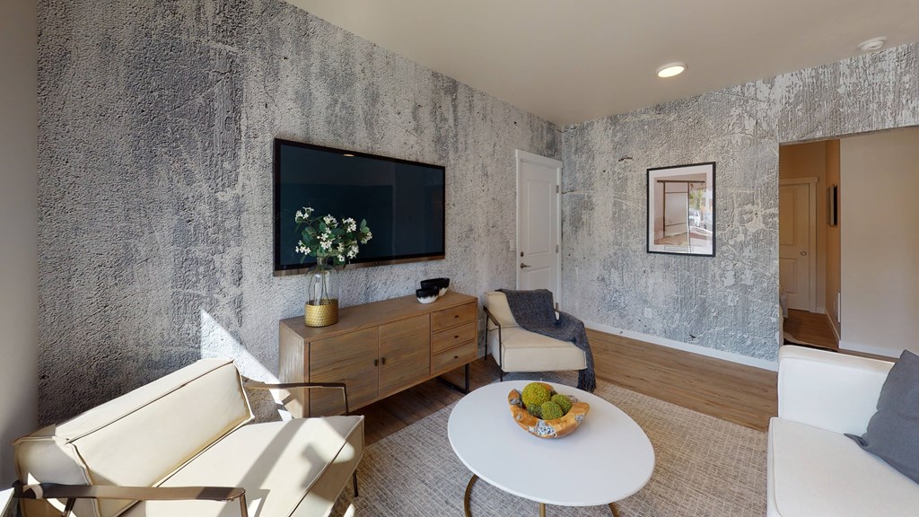 a living room with a white table and chairs and a television on the wall