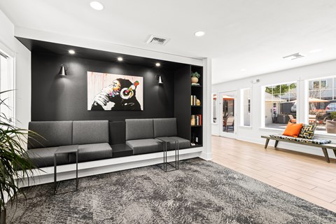A black and white photo is on the wall above a grey bench.