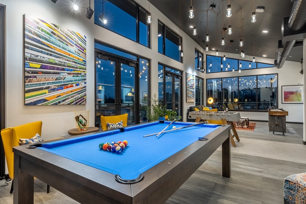 clubhouse with pool table at the district flats apartments in lenexa