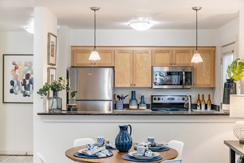A modern kitchen with a table set for two.
