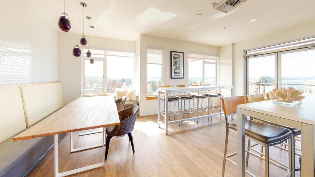 a dining room with a wooden table and chairs and a balcony