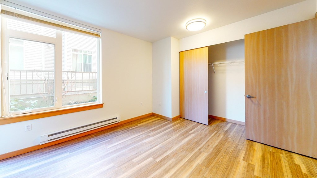 an empty room with wood floors and a closet