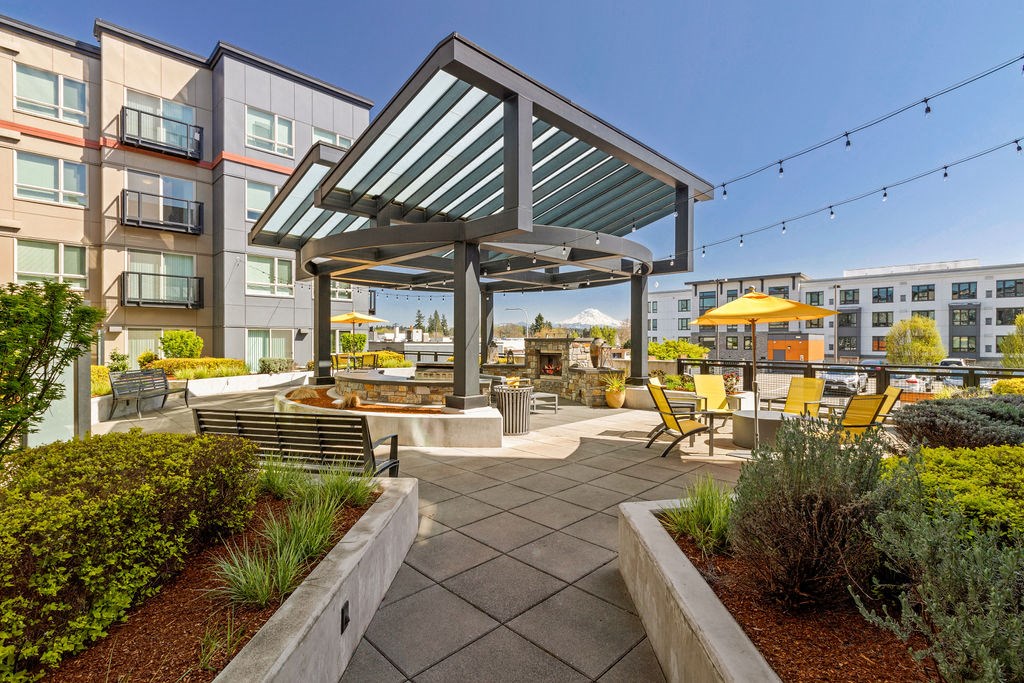 A patio with a table and chairs under a roof.