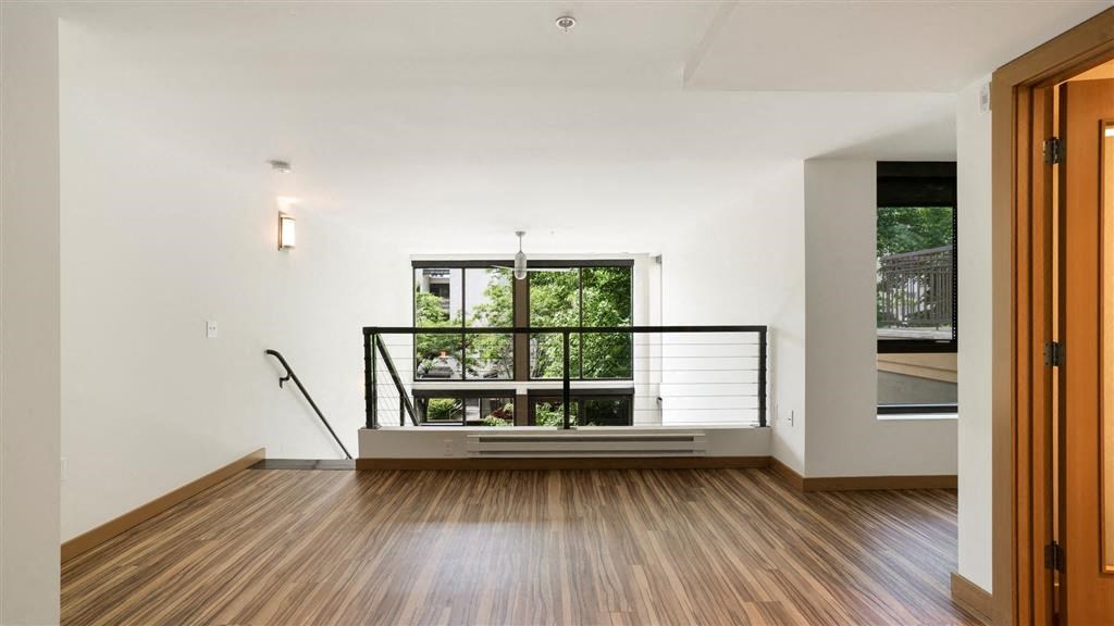 a living room with a large window and wooden floors