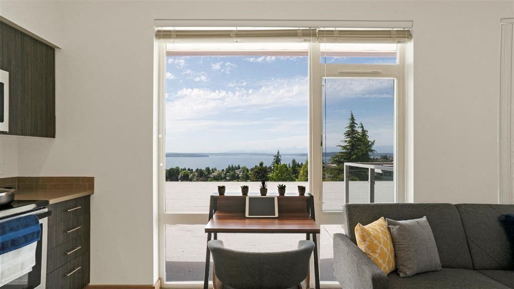 a living room with a couch and a table overlooking the ocean