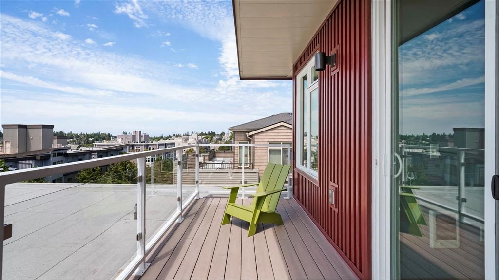 a balcony with a green chair and a view of the city