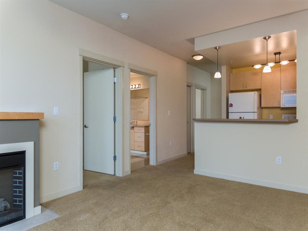 a living room with a fireplace and an open kitchen