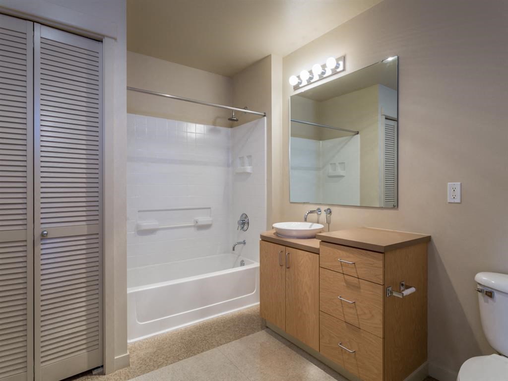 a bathroom with a shower and a sink and a mirror