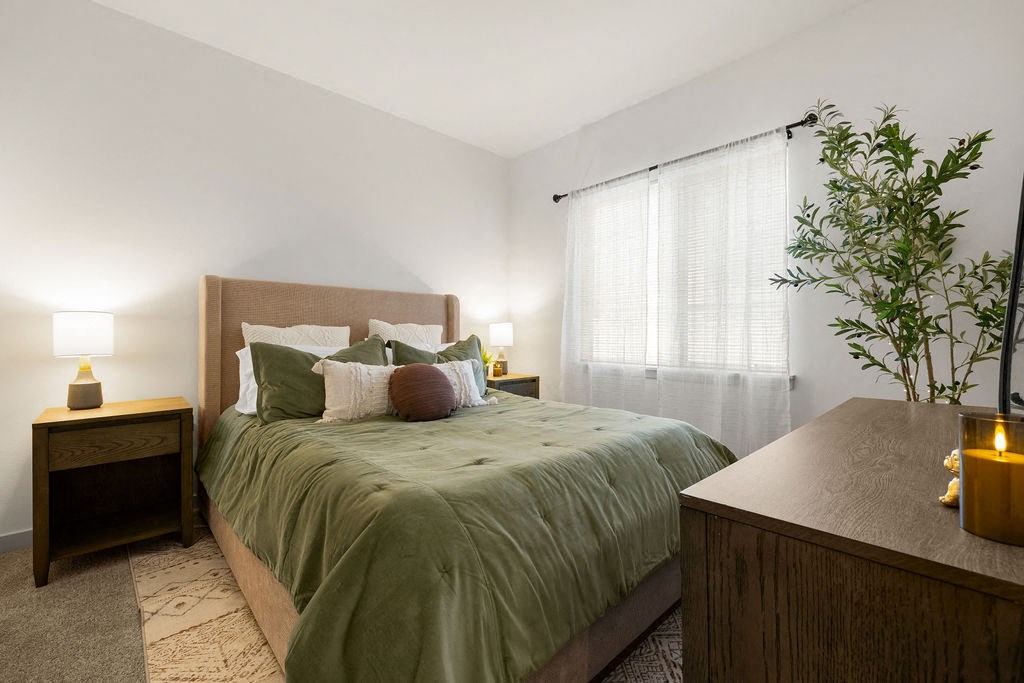 a bedroom with a bed and a dresser and a window