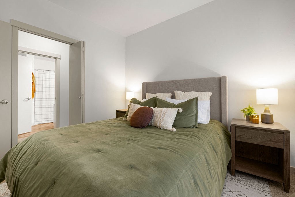 a bedroom with a bed and a door to a bathroom