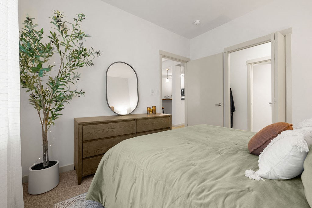 a bedroom with a bed and a potted plant