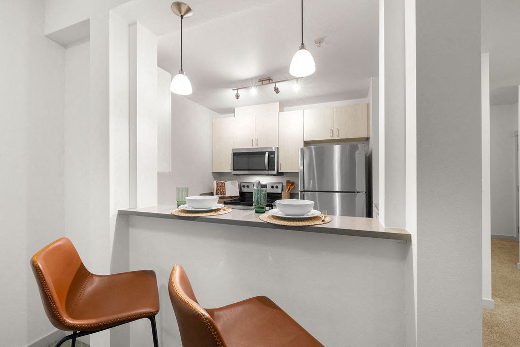 a kitchen with a counter top and a stainless steel refrigerator