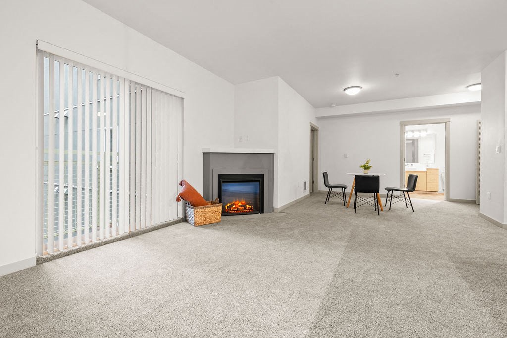 A living room with a fireplace and a dining table.