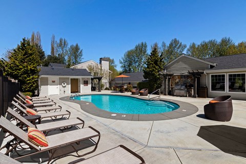 a swimming pool and lounge chairs in front of a house