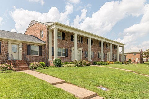 A row of houses with green lawns in front.