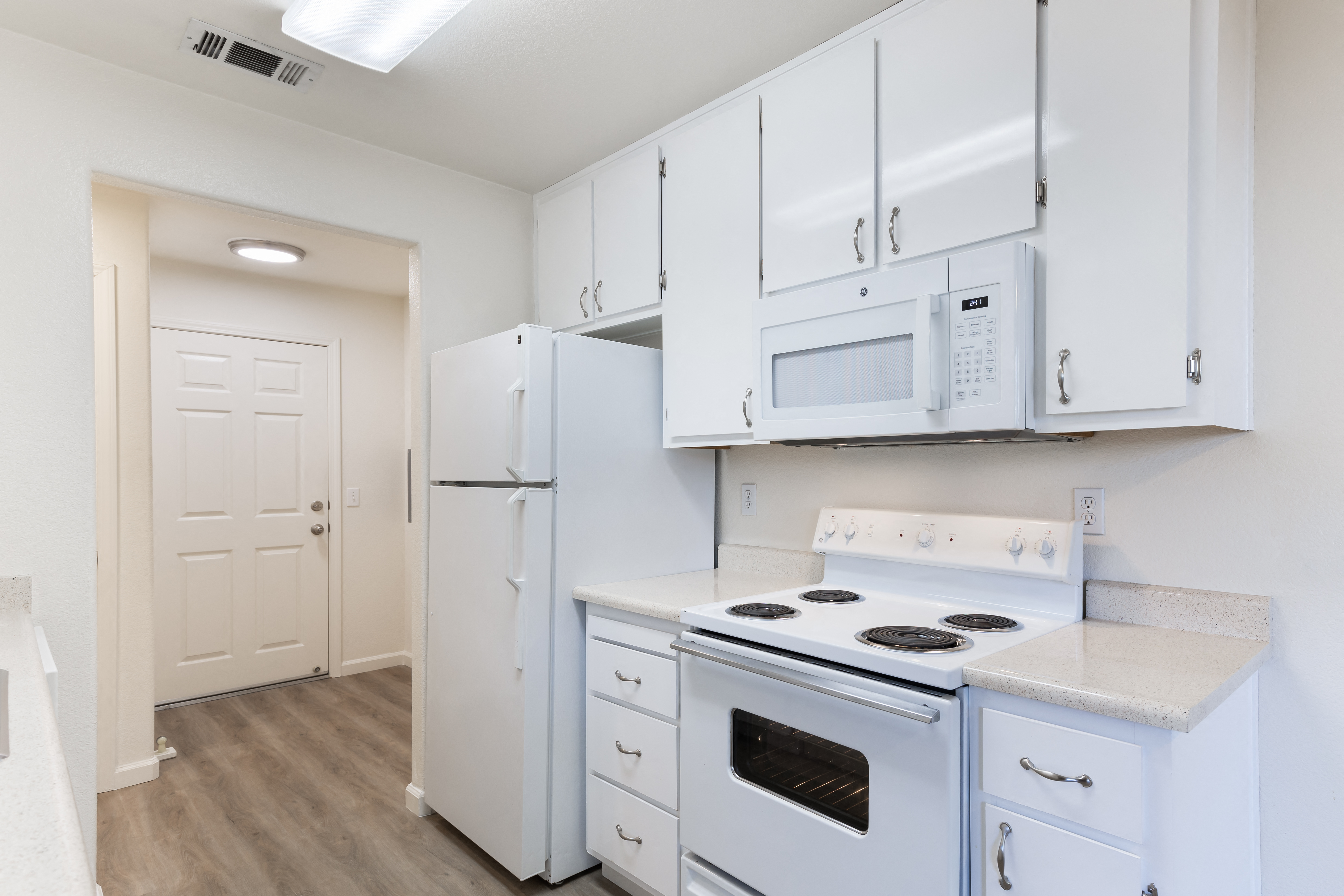 a white kitchen with white appliances and white cabinets