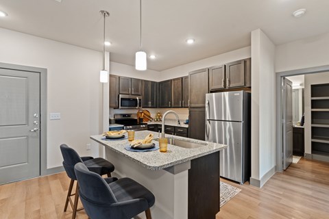 A modern kitchen with a dining table set for two.